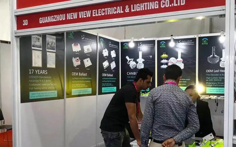NVEL sales team showcasing LED headlight kits and Bi-LED projector lenses at automotive exhibition booth